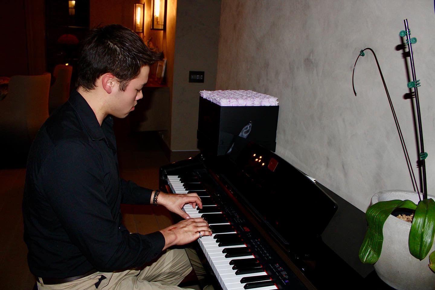 Taka Khoo playing piano, with his hands on the keys
